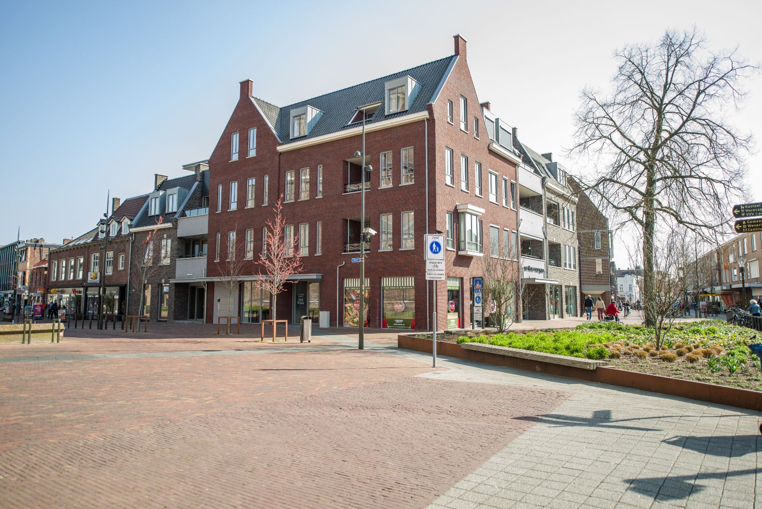 Straatbeeld met moderne bakstenen gebouwen en plein.