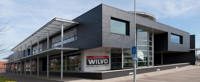 Modern bedrijfsgebouw met logo WILVO aan gevel.