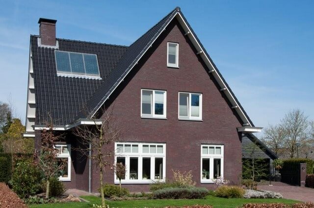 Bakstenen huis met zonnepanelen en tuin