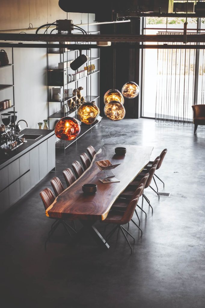 Moderne eettafel met designlampen en boeken