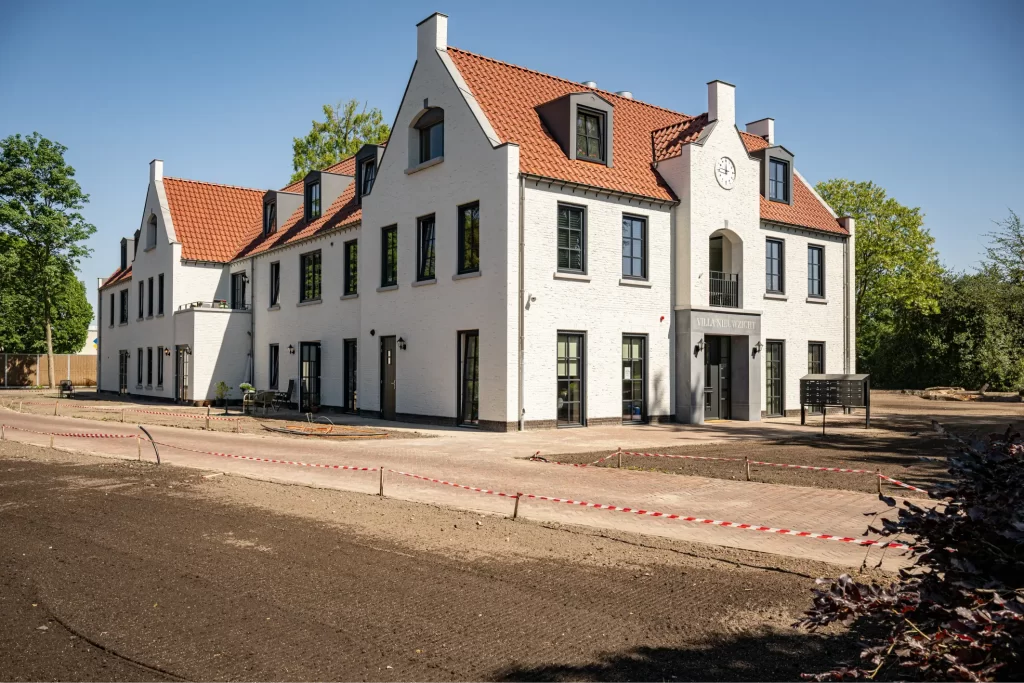 Wit gebouw met rode daken in constructiegebied.