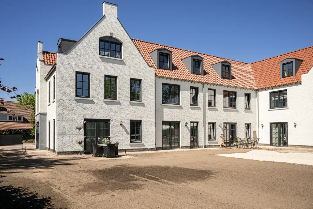Wit, modern bakstenen huis met rode dakpannen