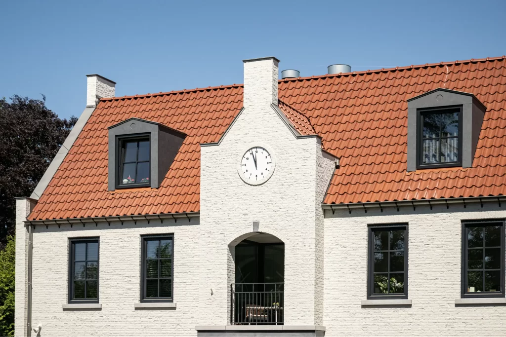 Huis met rode dakpannen en klokgevel.