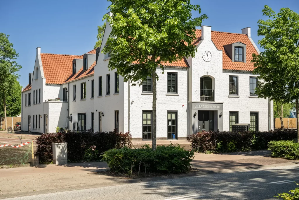 Wit gebouw met klok en rode dakpannen