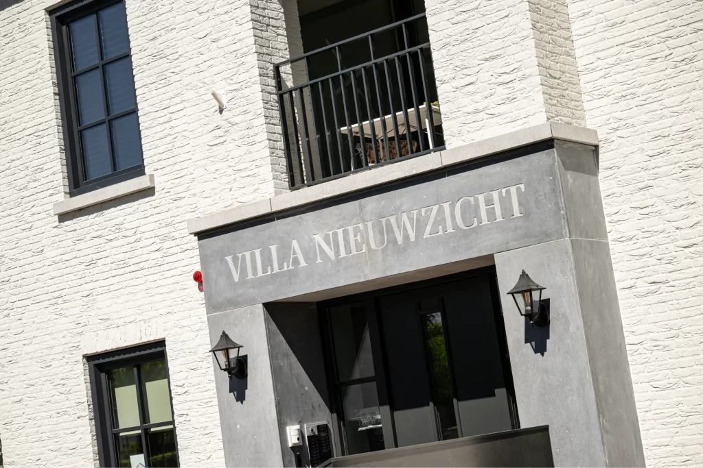 Gevel Villa Nieuwzicht met balkon en lampen.