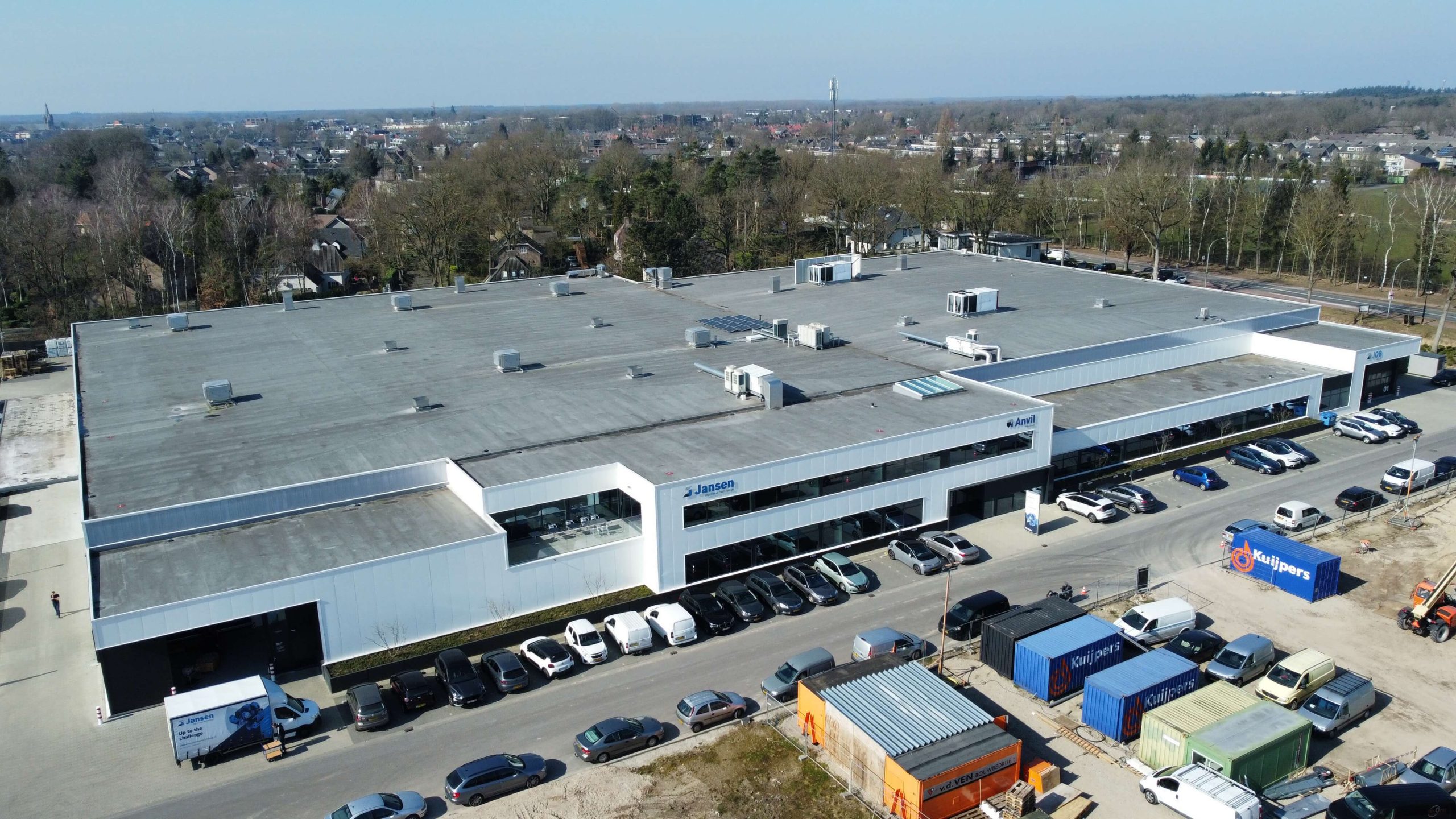 Industrieel gebouw met geparkeerde auto's en containers