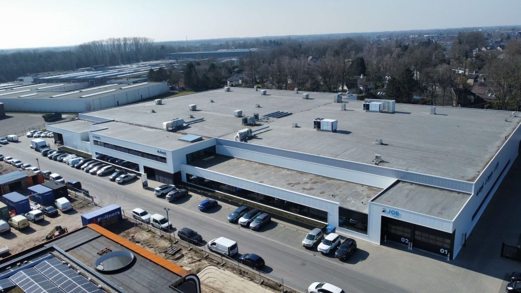 Luchtfoto van industrieel gebouw met parkeerplaats.