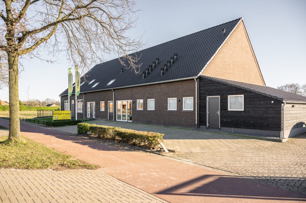 Boerderij met moderne groene vlaggen op zonnige dag.