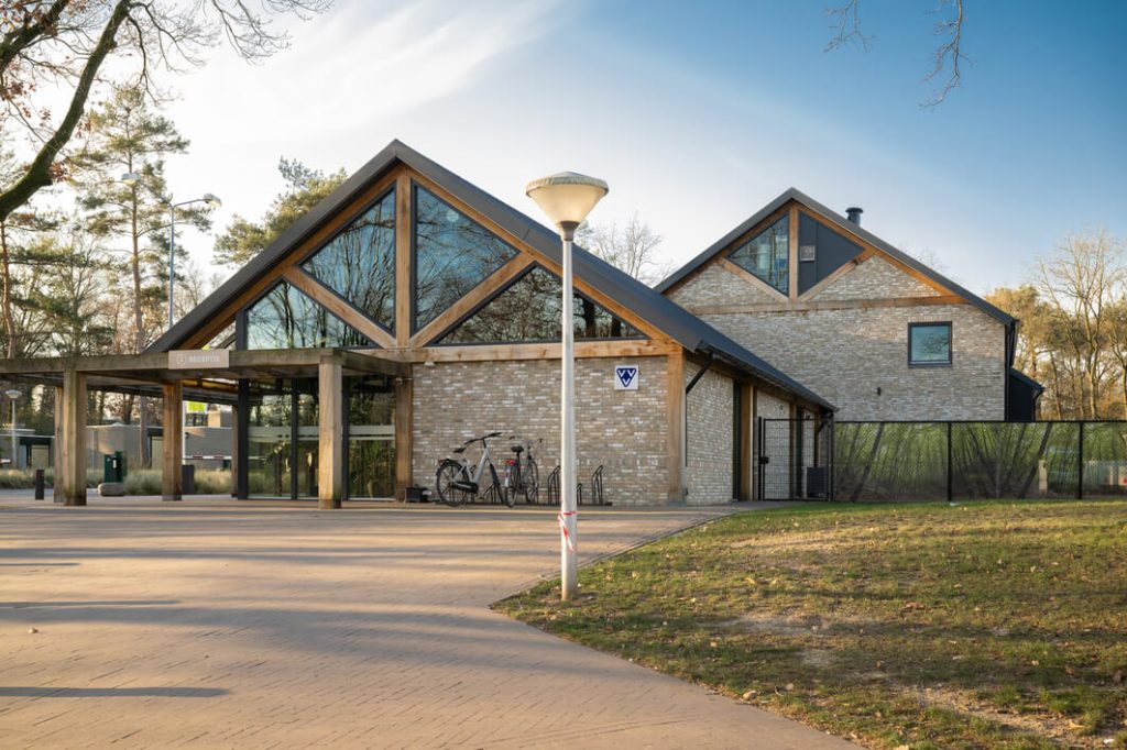 Modern gebouw met glas en bakstenen, fietsen geparkeerd.