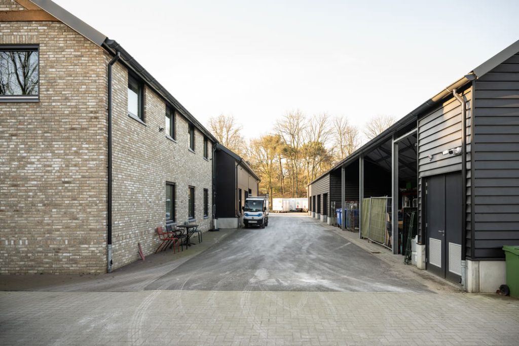 Industriële gebouwen met geparkeerde vrachtwagen en containers.