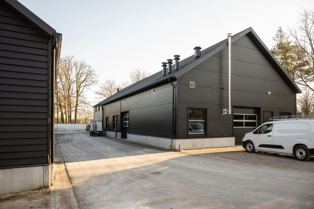 Modern industrieel gebouw met bestelwagens buiten