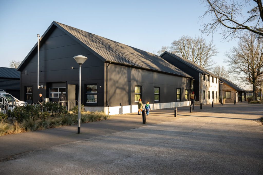 Modern gebouw met zwarte gevel en parkeerplaats