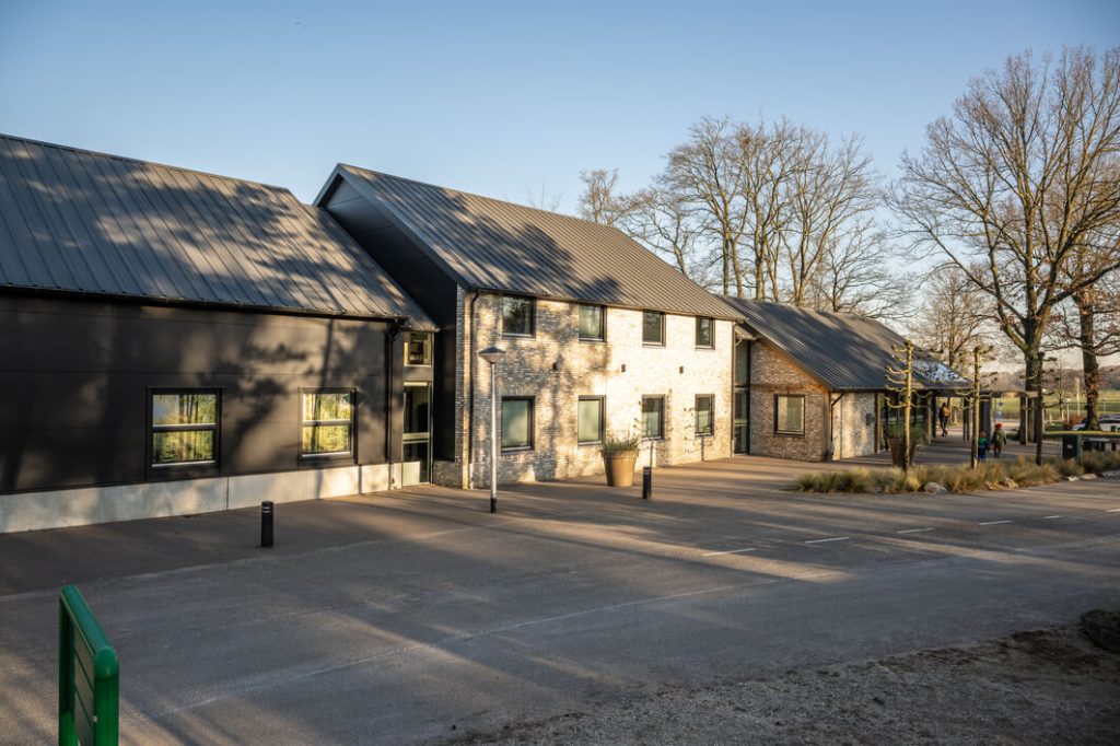 Modern gebouw met stenen gevel en tinnen dak.