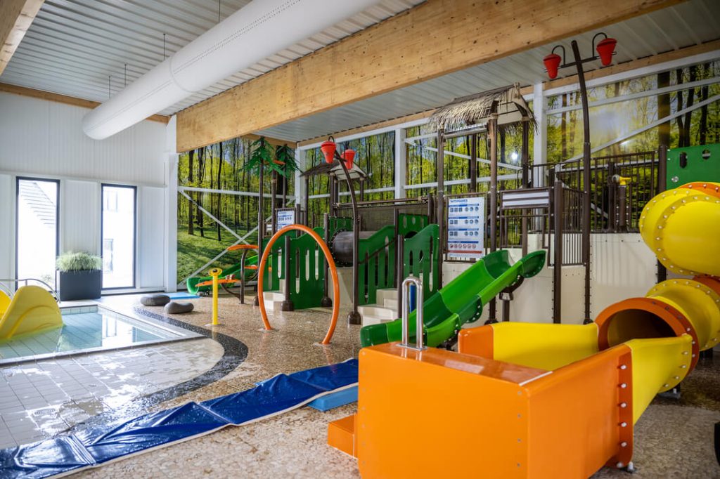 Indoor speeltuin met glijbanen en zwembad voor kinderen.