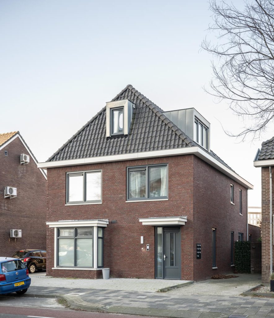 Bakstenen huis met grijs dak en moderne uitstraling.