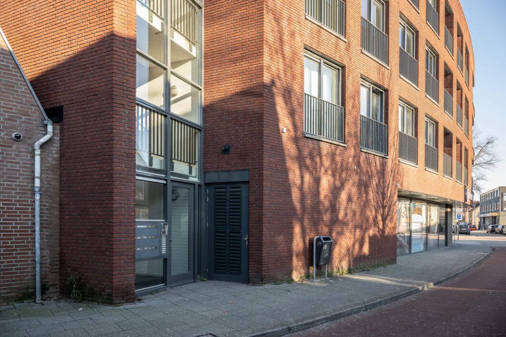 Moderne bakstenen appartementencomplex op zonnige dag.