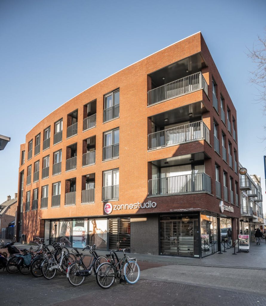 Modern appartementencomplex met fietsen buiten.