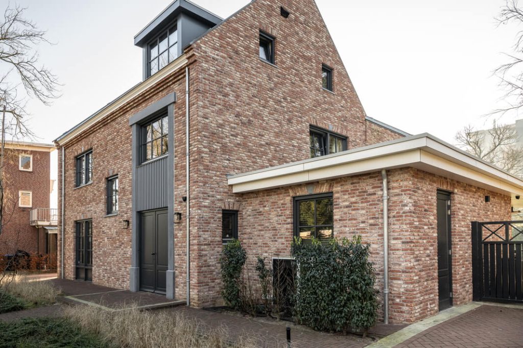 Moderne bakstenen huis met grote ramen.