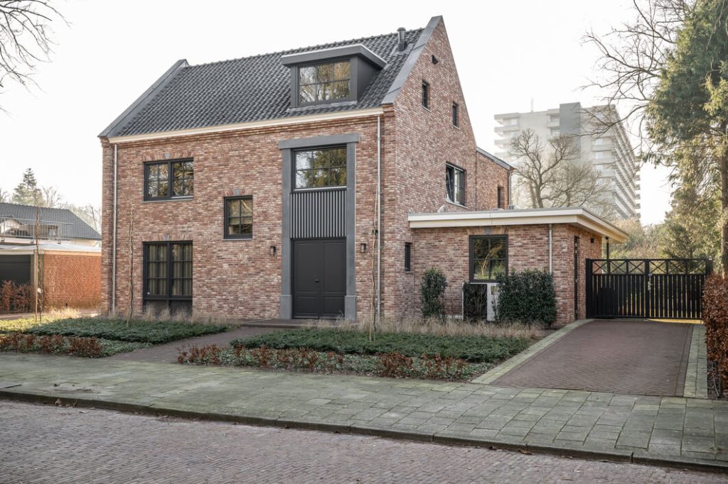 Bakstenen huis met oprijlaan en erf.