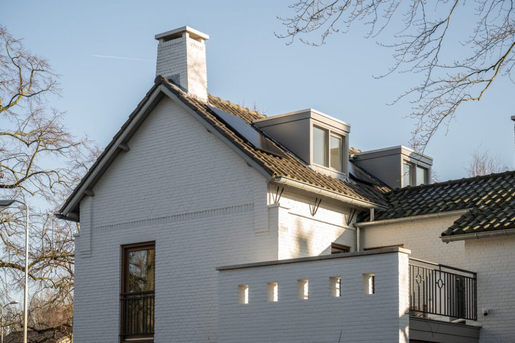 Wit huis met zonnepanelen op het dak.