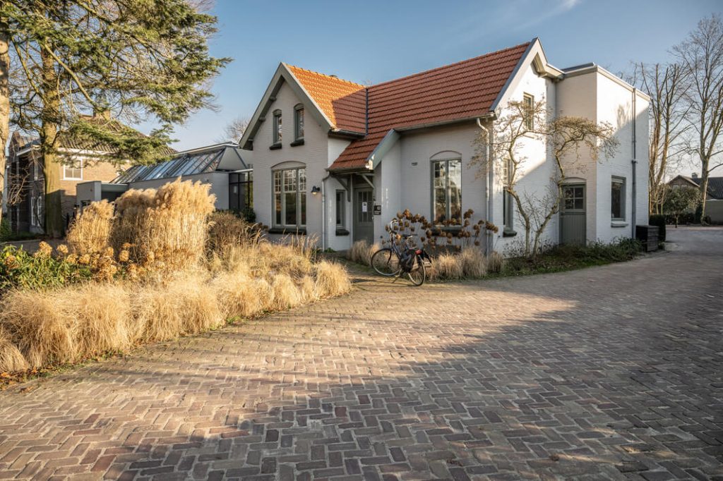 Wit huis met rode dakpannen en tuin