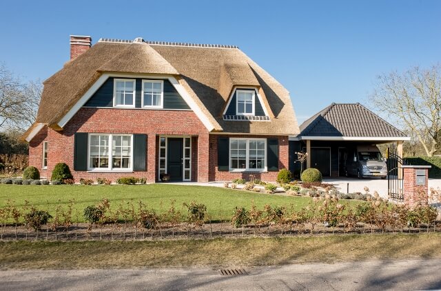 Traditioneel huis met rieten dak en tuin