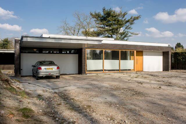 Modern huis met geparkeerde auto voor deur.