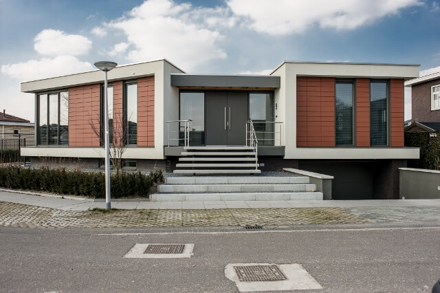 Modern huis met grote ramen en witte muren.