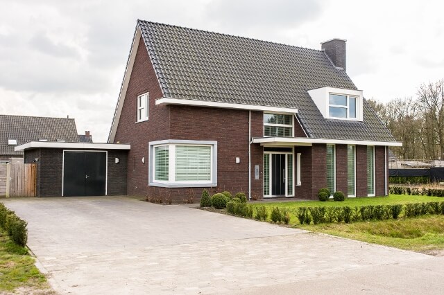 Moderne bakstenen woning met oprit en garage.