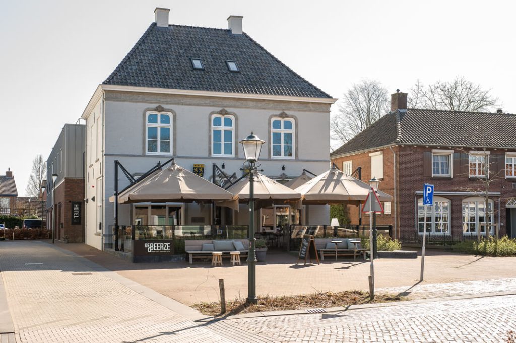 Historisch gebouw met terras en parasols in Nederland.