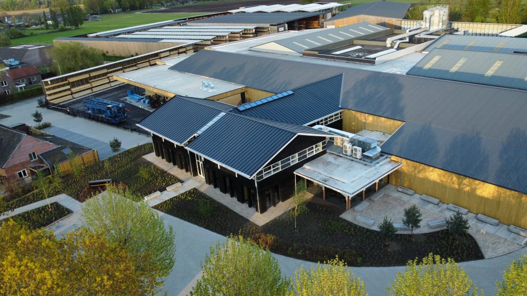 Luchtfoto van modern bedrijfsgebouw in groene omgeving.