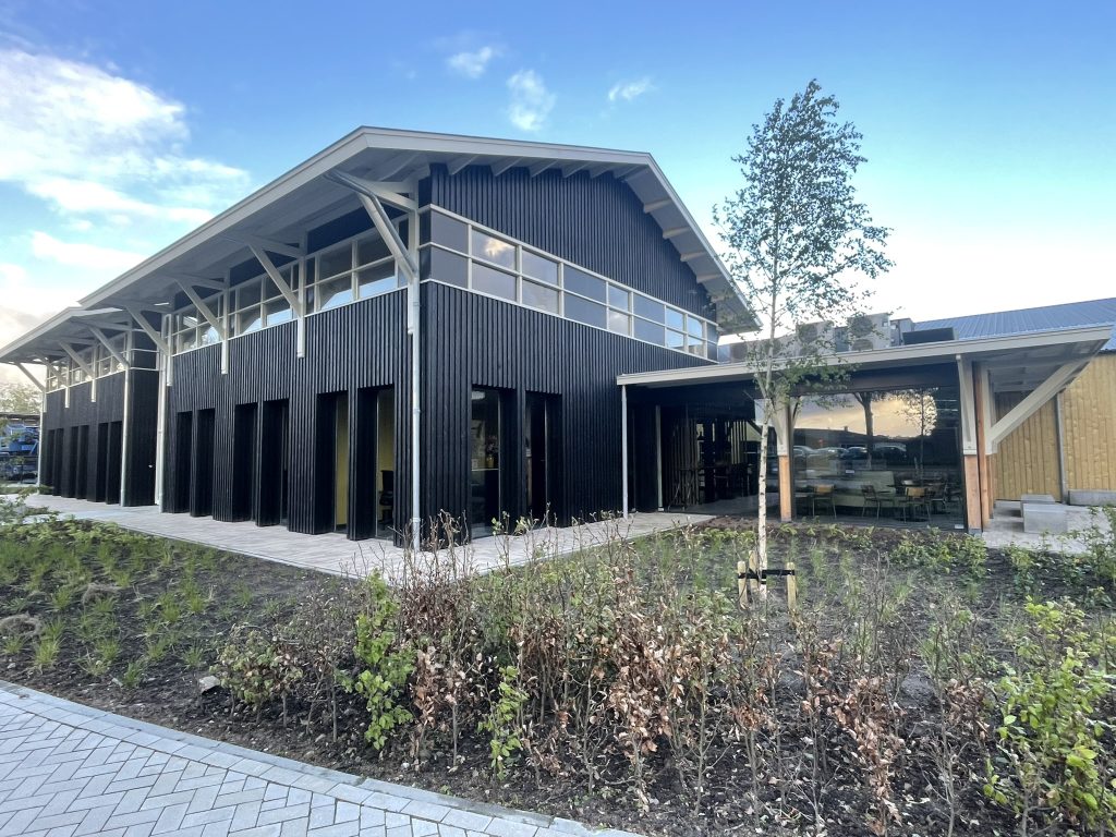 Modern houten gebouw met grote ramen en tuin