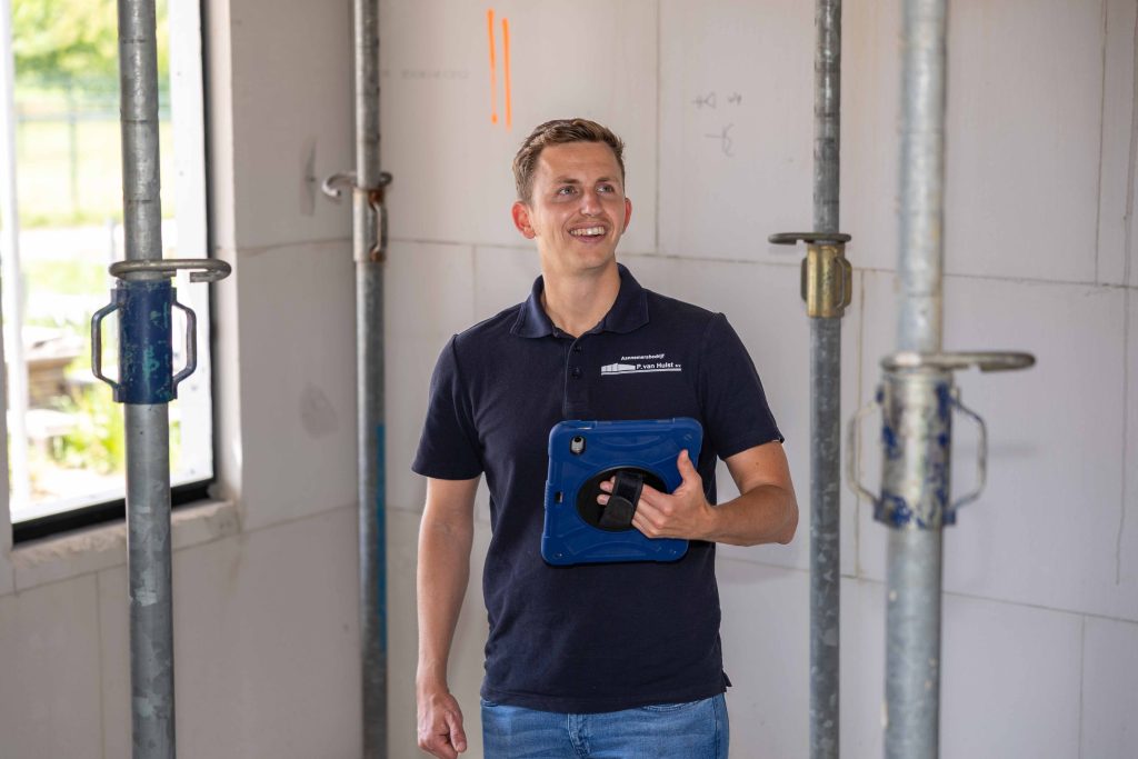 Bouwplaatswerker met tablet in hand.